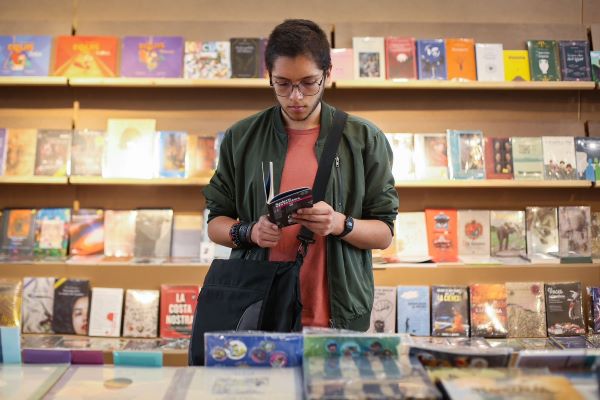 Joven leyendo un libro en una librería